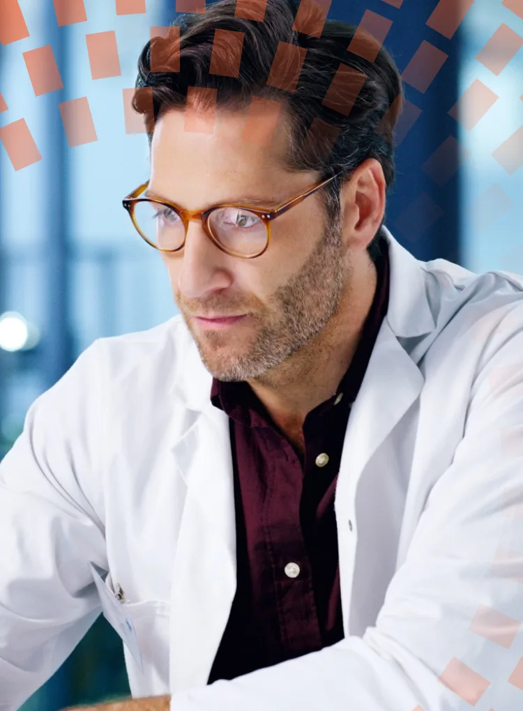 A mature doctor using a laptop in a hospital