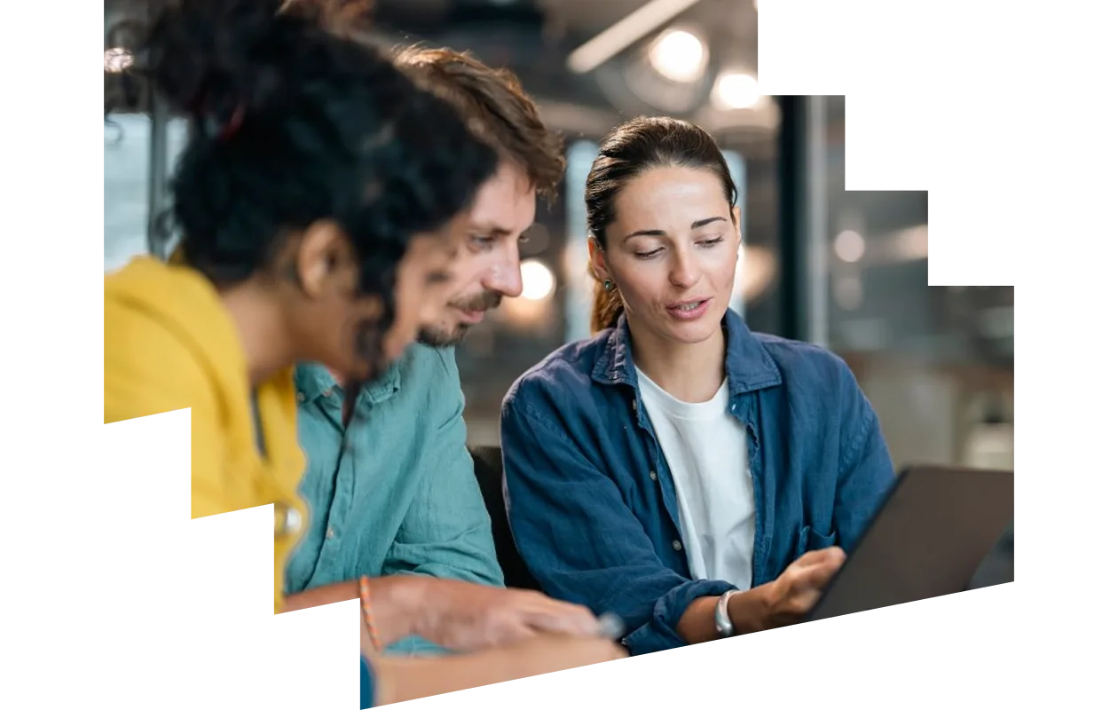 Diverse colleagues looking at a laptop together in a modern office