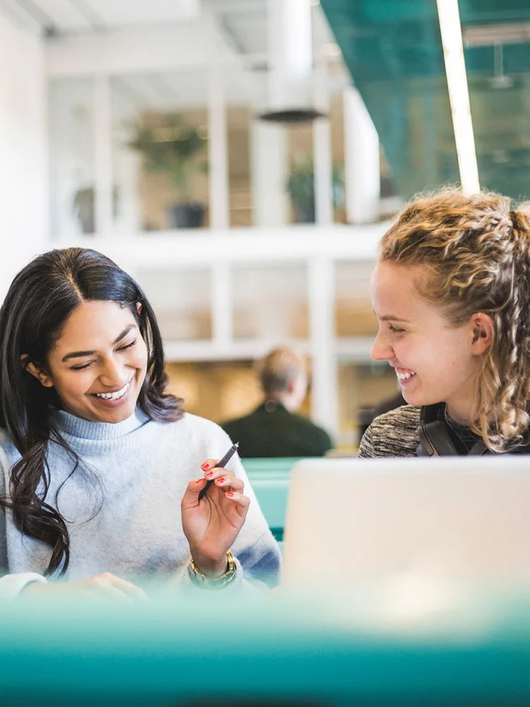 Two female students collaborating in library