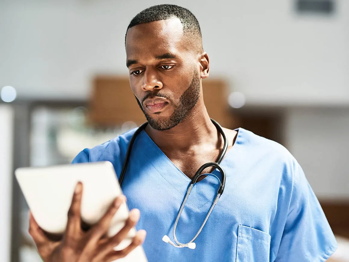 Male nurse looking at tablet