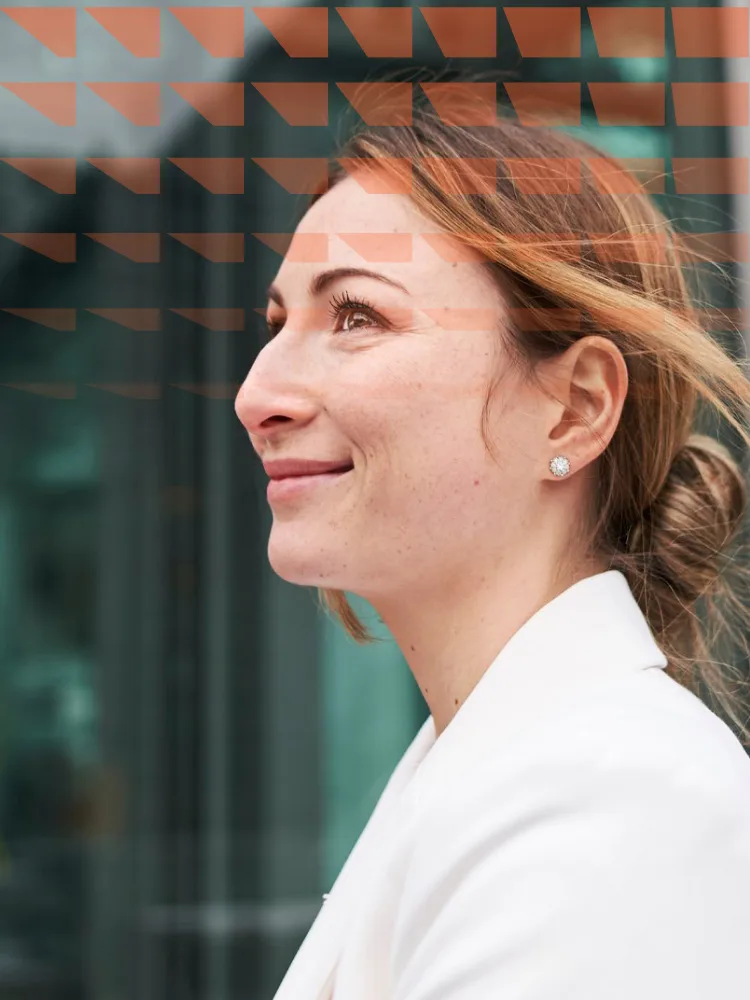 Smiling young businesswoman in front of a building