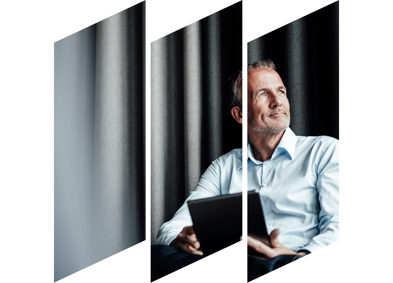 Contemplating businessman with digital tablet sitting on armchair looking away