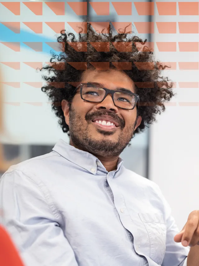 A smiling man wearing glasses, looking friendly and approachable.