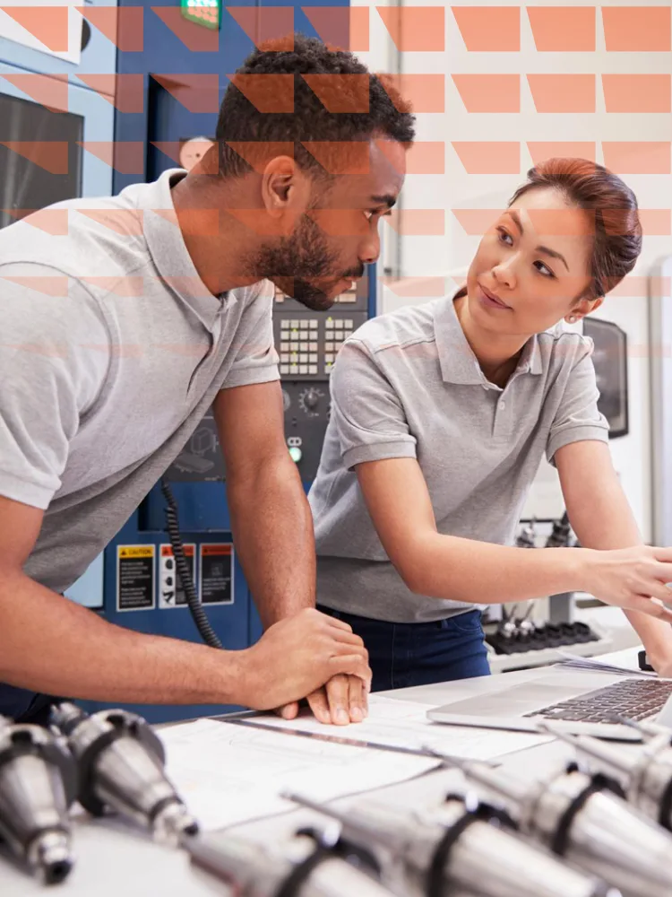 Man and woman engaged in discussion while looking at a tablet together.