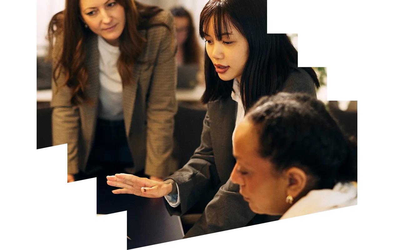 Woman with a laptop and phone smiling at a colleague