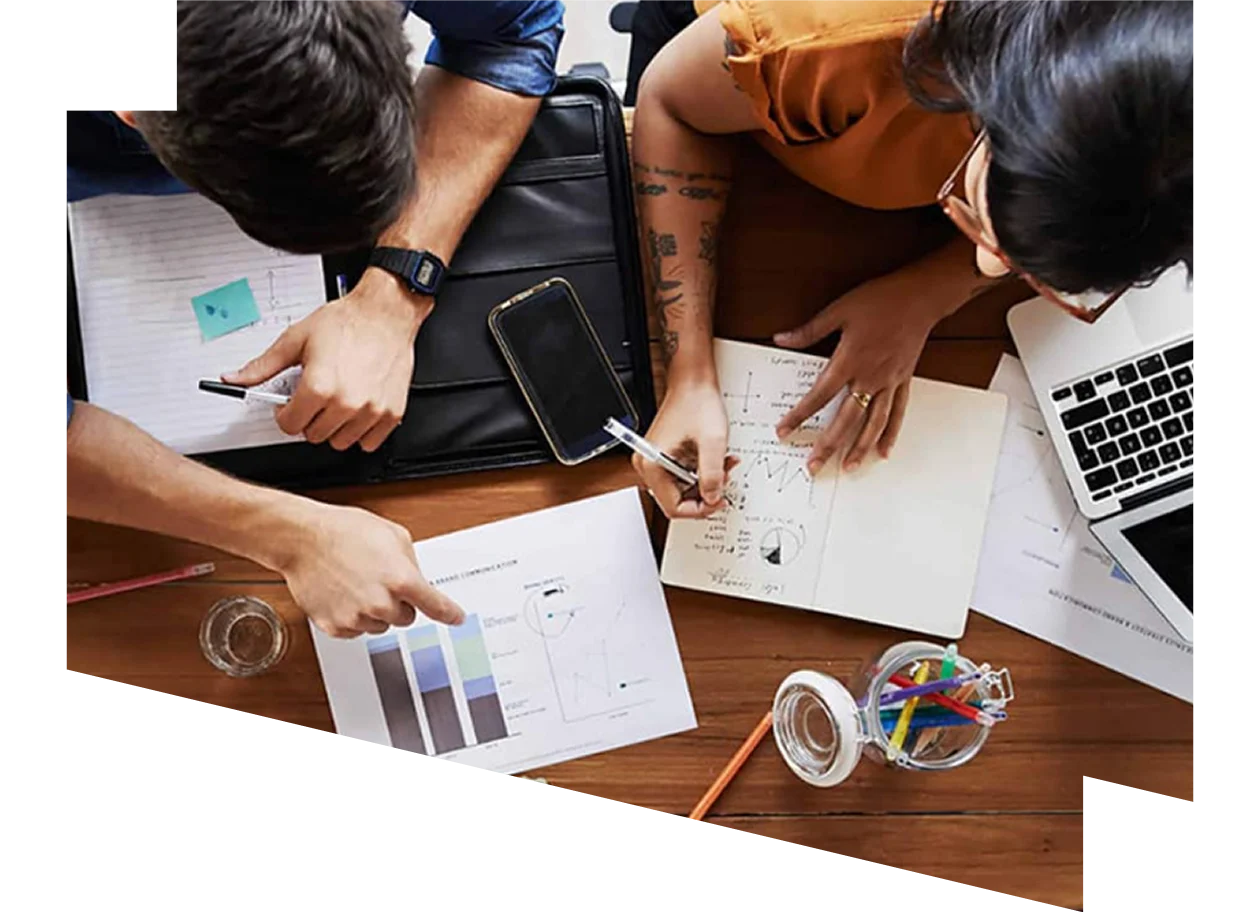 View from above of young colleagues evaluating data together round a table