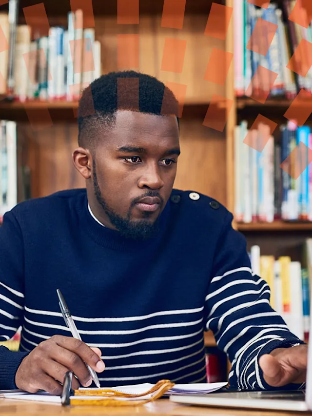 Male author writing notes in a library