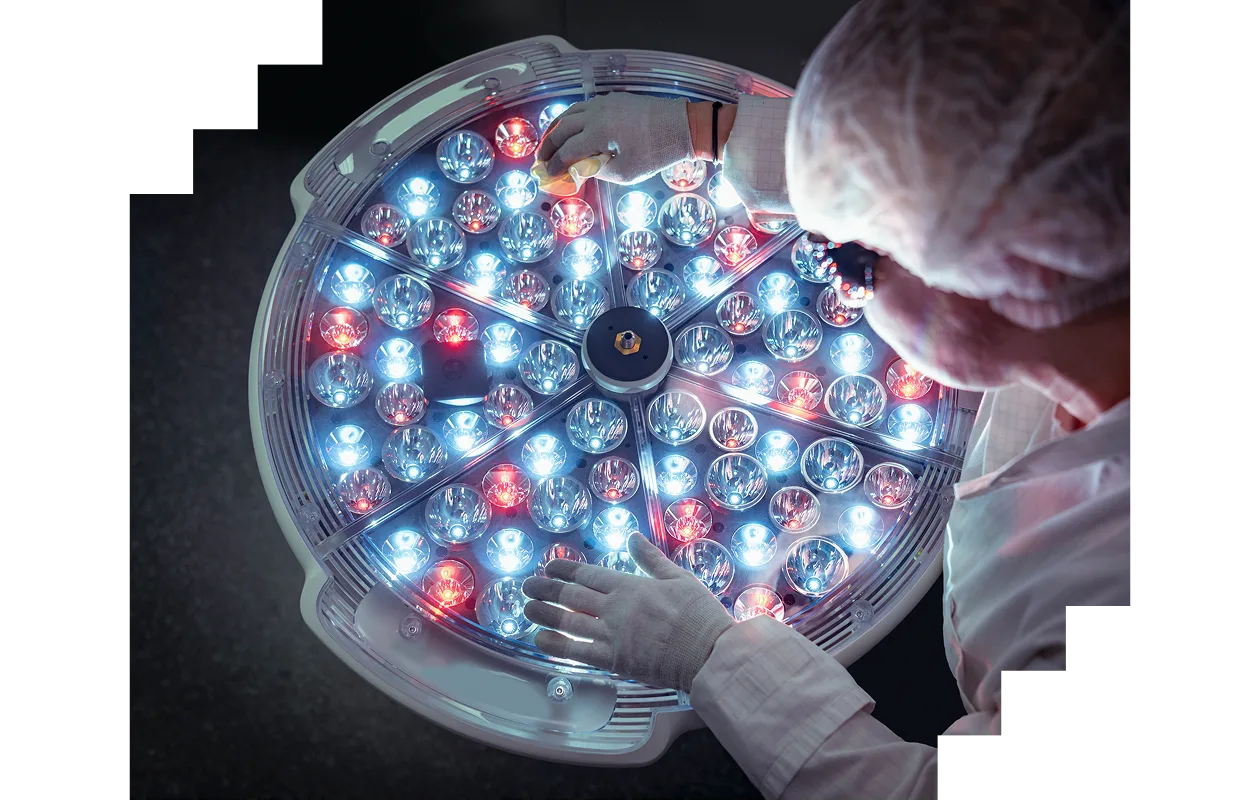 Female engineer preparing operating theatre light in factory clean room