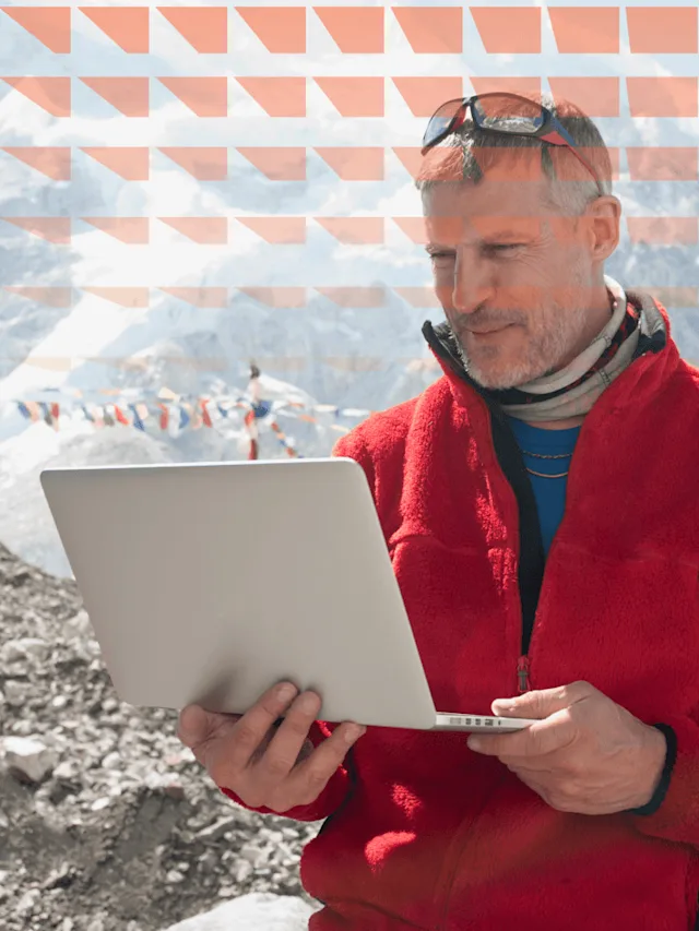 Man using laptop on snowy mountain