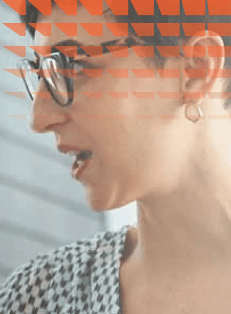 Middle aged woman with glasses speaking to a group, with one visible colleague