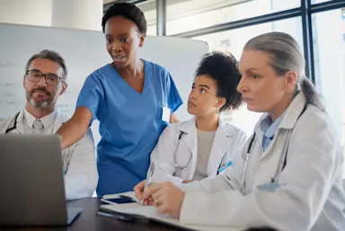 Team of doctors and nurses working together in front of a computer at the hospital