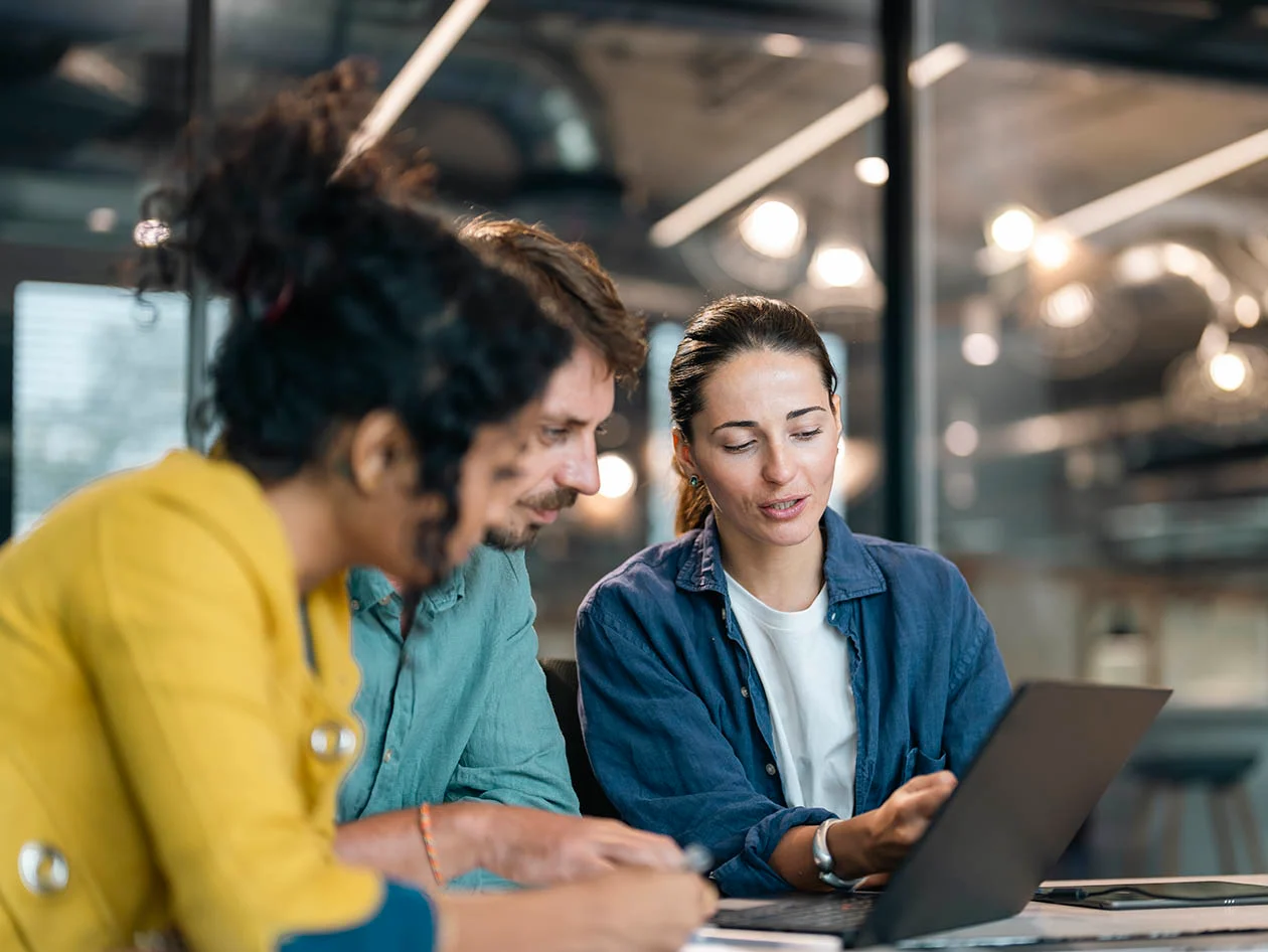 Photo conveying three young researchers collaborating over a laptop (PixeloneStocker/Moment via Getty Images)