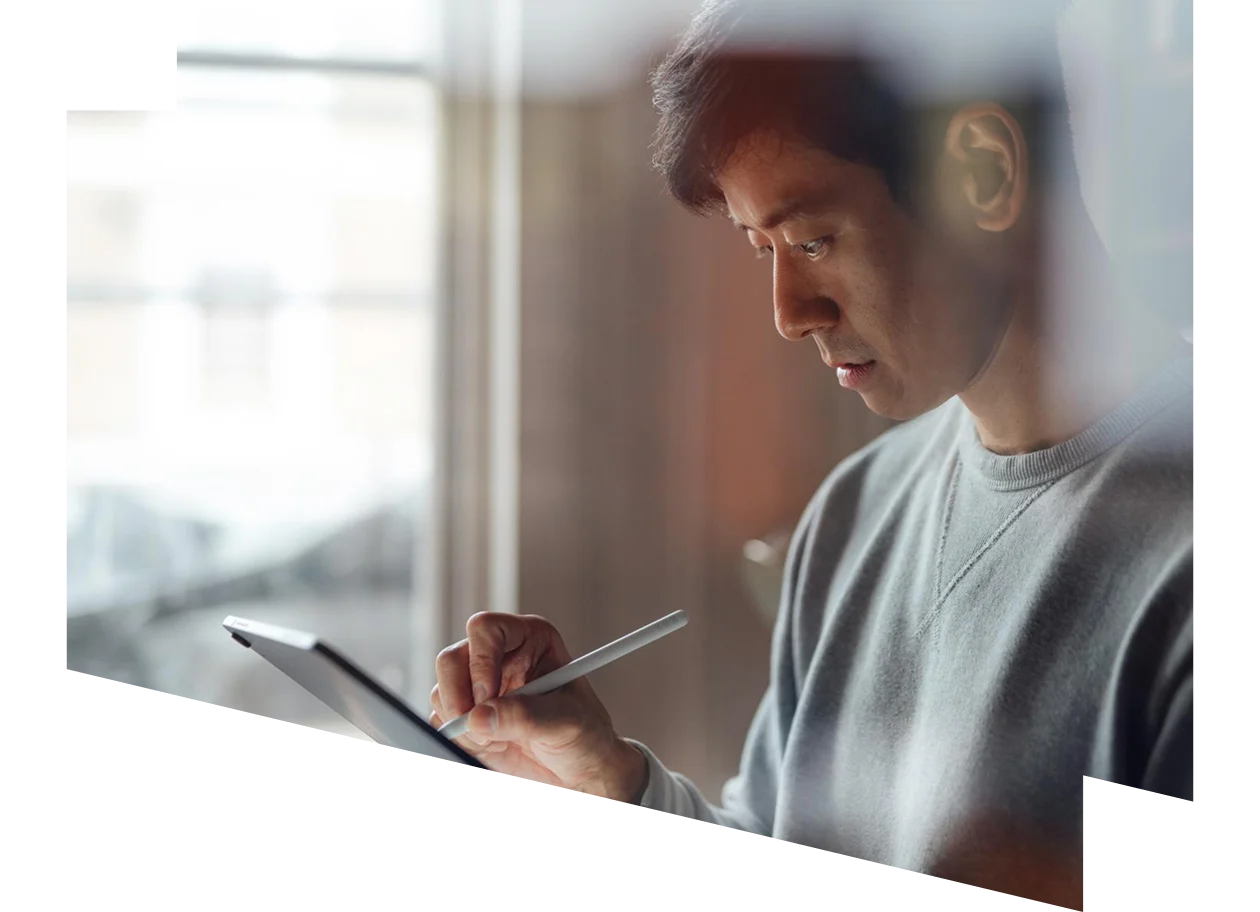 Man at his desk and looking at iPad