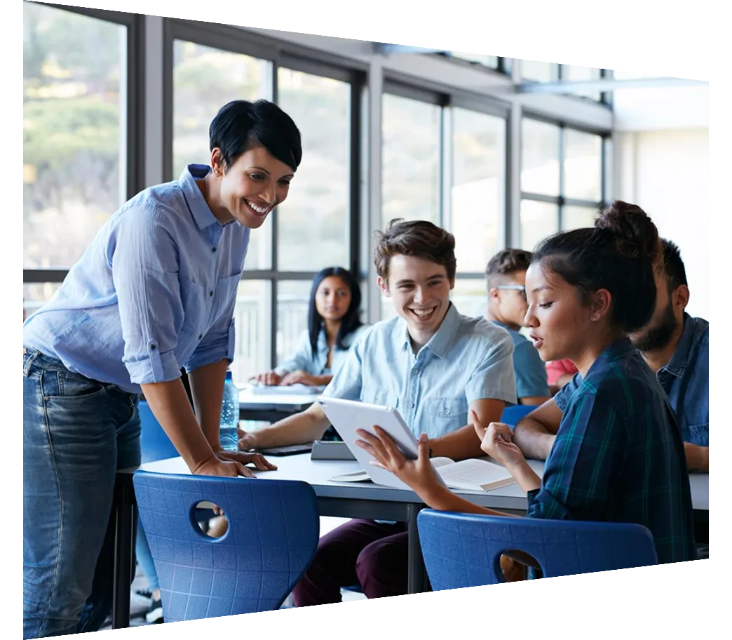 Teacher assisting a group of students in a classroom