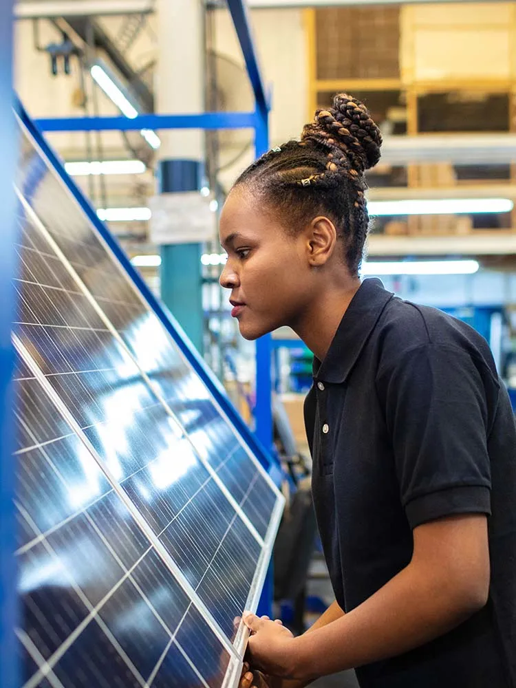 Employee working with solar panels at manufacturing plant