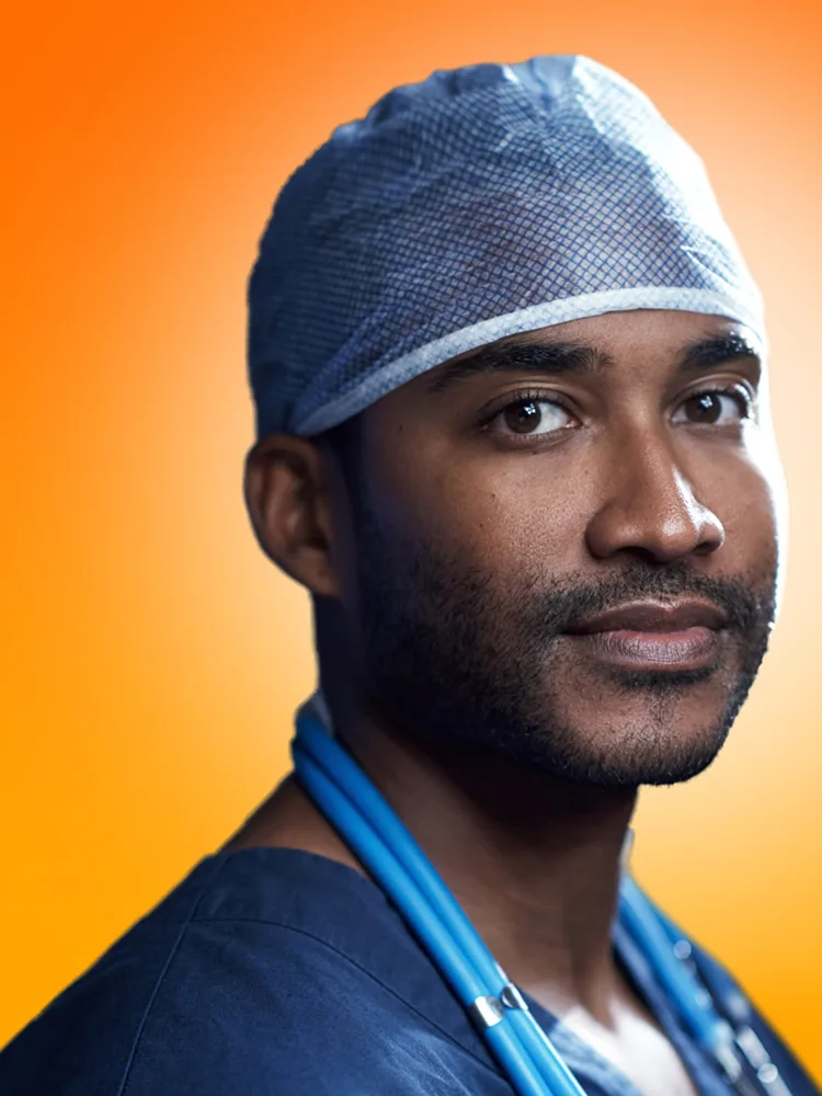 Doctor in scrubs against orange background - portrait