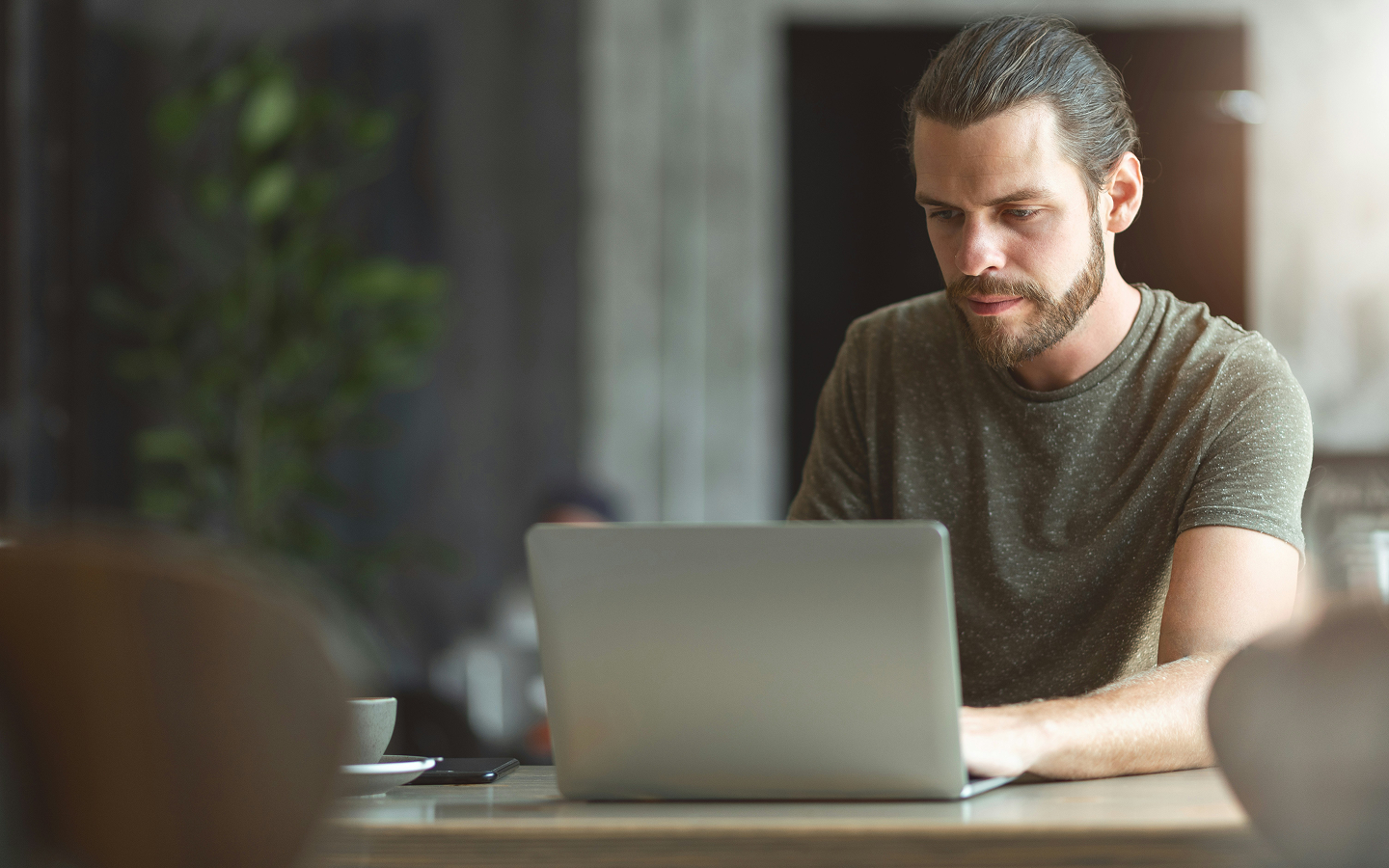 A person sitting and looking at their laptop