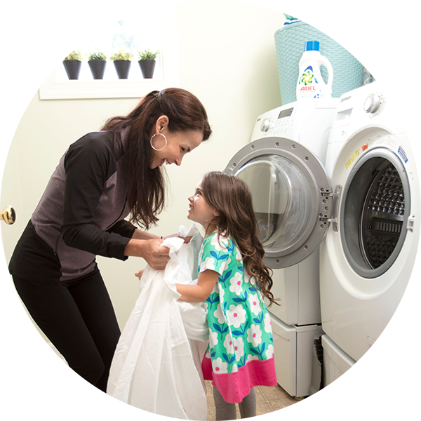 Mother daughter in front of the washing machine