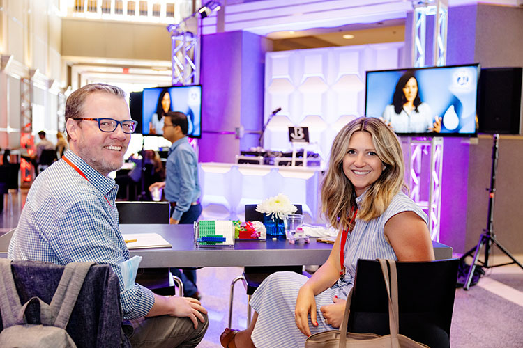 Two people smiling and looking at a camera at Signal recap