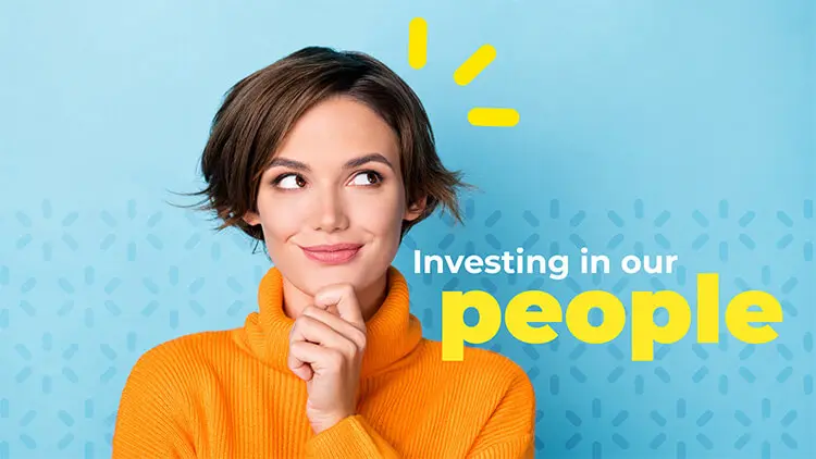 A woman with short, brown hair, wearing an orange turtleneck sweater and standing against a light blue backdrop, holds her left hand to her chin and wears an expression of curious thought. She stands next to the tagline, "investing in our people."