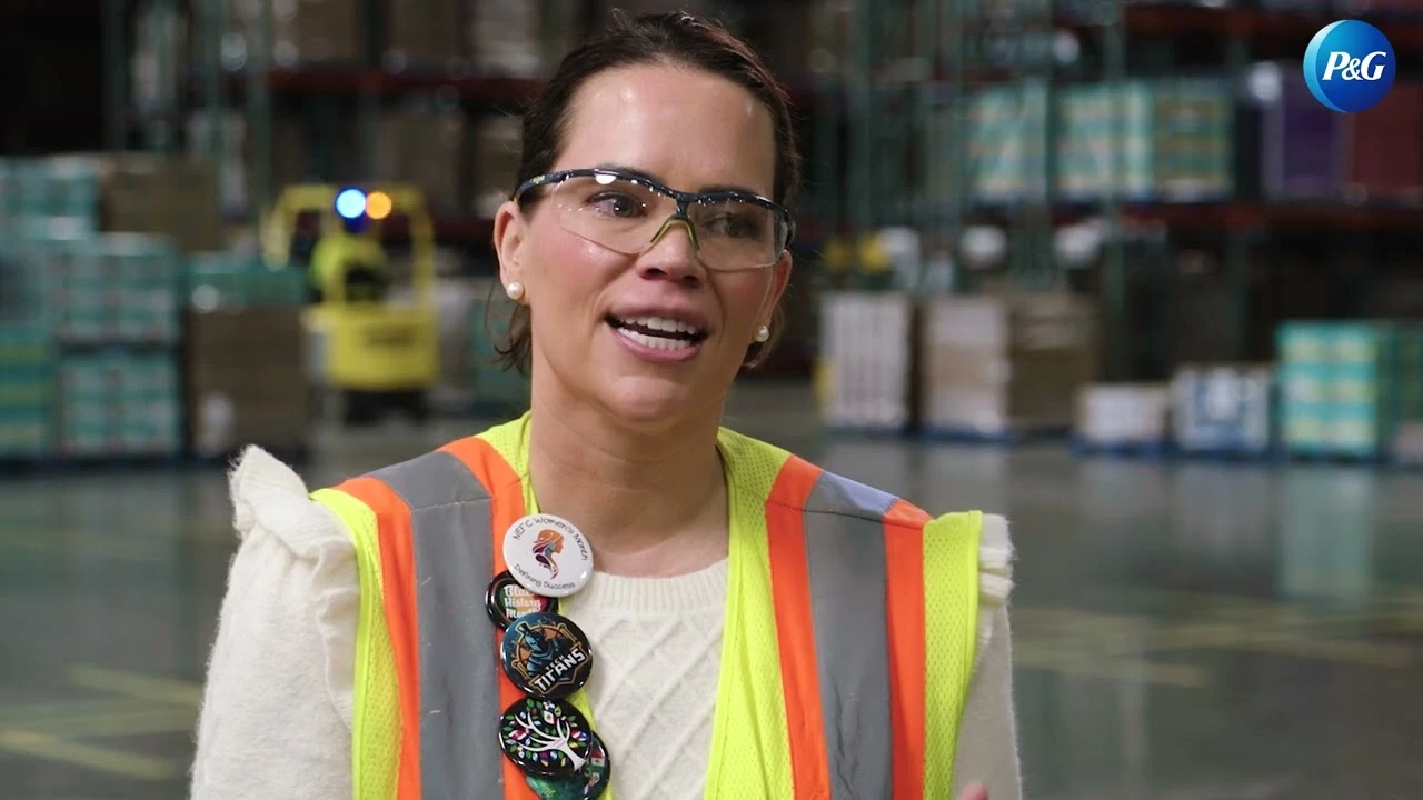Site leader speaking in large warehouse with operational equipment in background