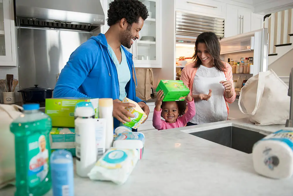 Photo of father, mother and daughter using P&G products in their kitchen