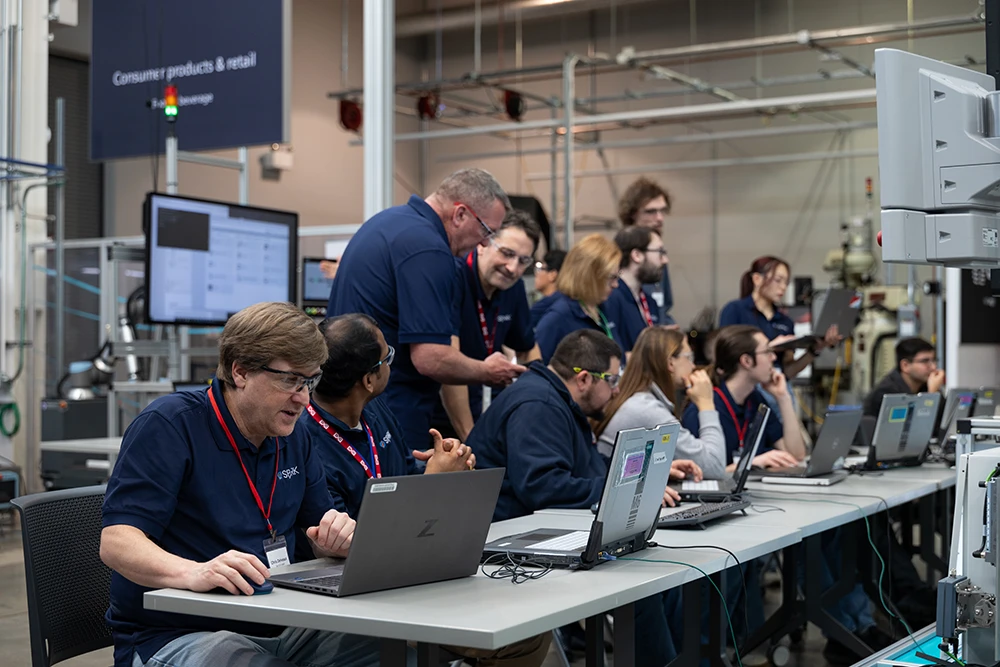 P&G employees at laptop computers run manufacturing simulations during a SPARK training session.