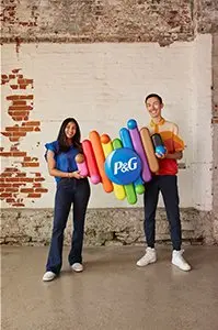 Two employees holding a heart with P&G logo and rainbow colors