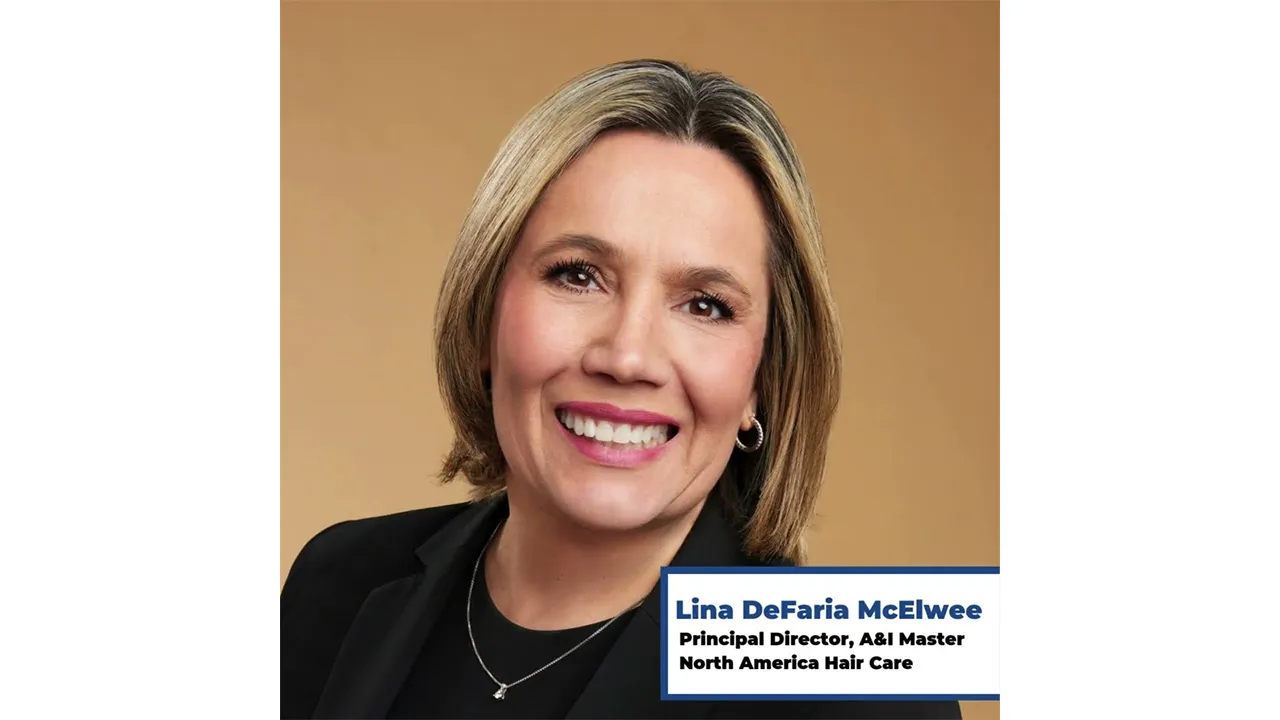 Woman with short medium blond hair smiling looking towards the camera.