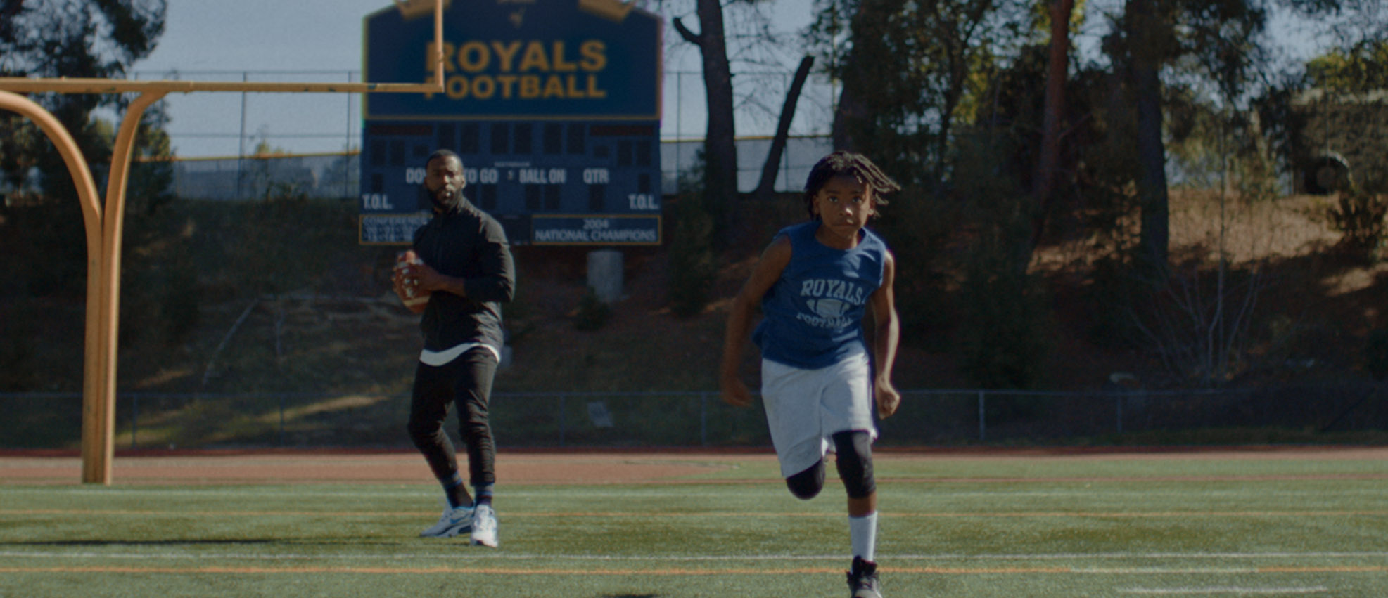 Boy playing football with his dad