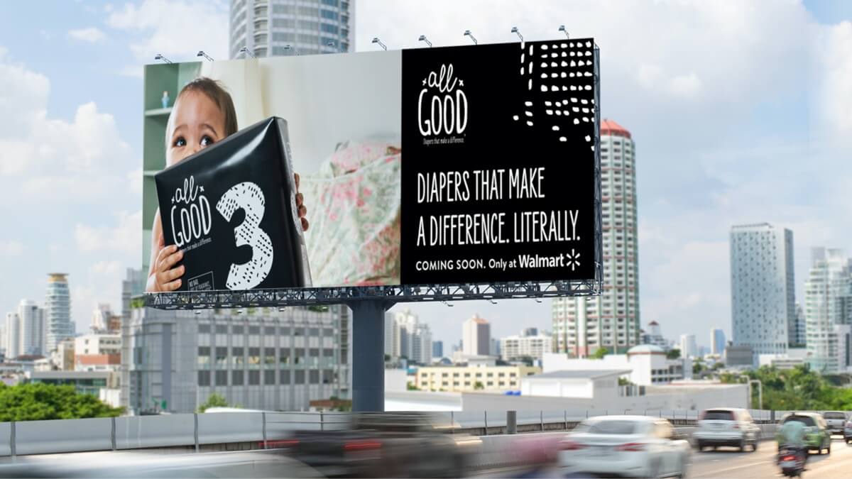 Baby holding package of All Good Diapers