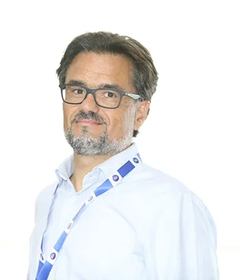 A man in a white collared shirt and dark rimmed glasses.