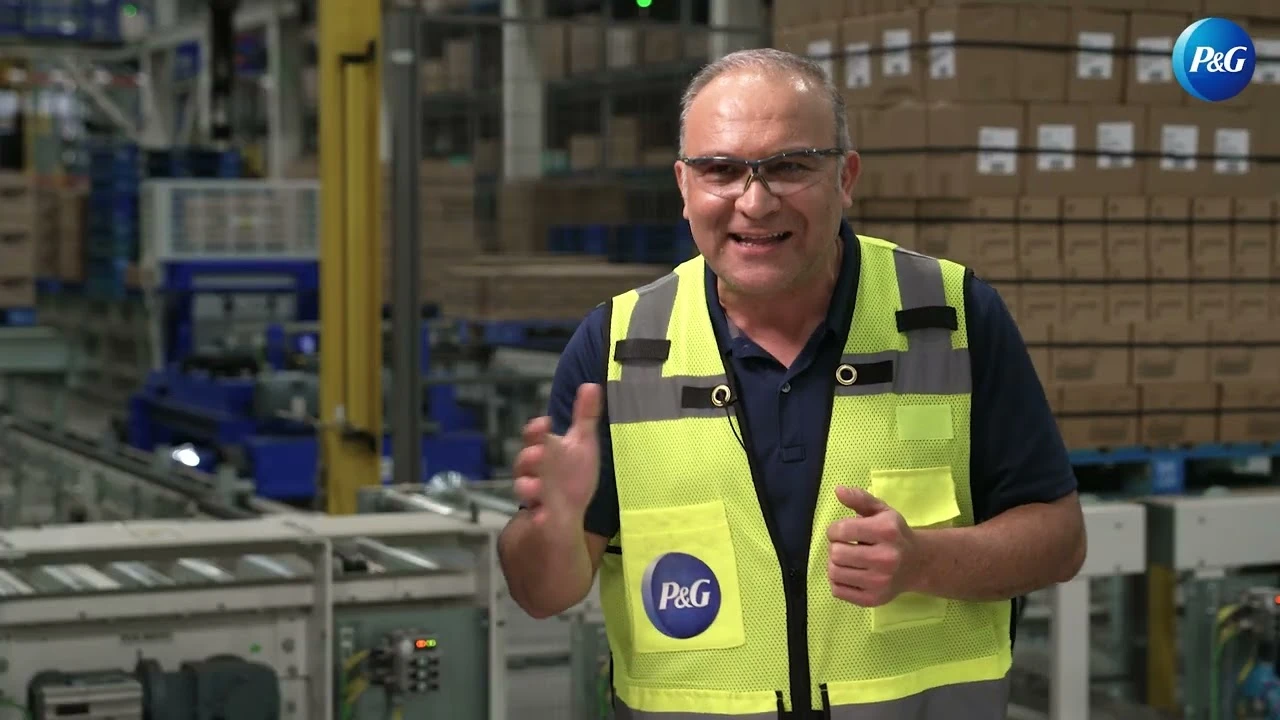 Site leader speaking in warehouse with conveyor systems and loading area