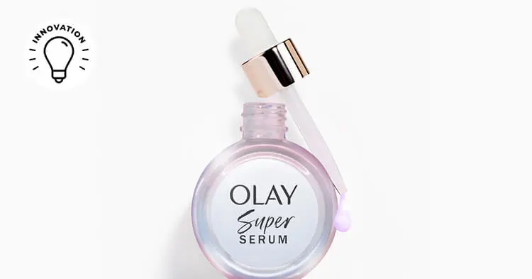 A light pink, iridescent Olay super serum bottle on a white background, with "Olay Super Serum" written on it. A dropper rests on the top right, releasing a serum drop. An "innovation" illustration with a light bulb is in the top left corner.