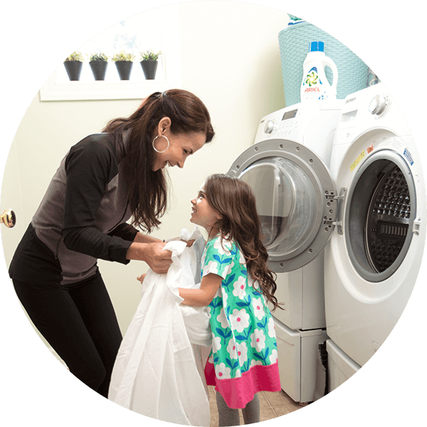 Mother daughter in front of the washing machine