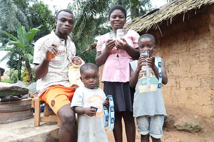 Family holding P&G purified water and purifying packets