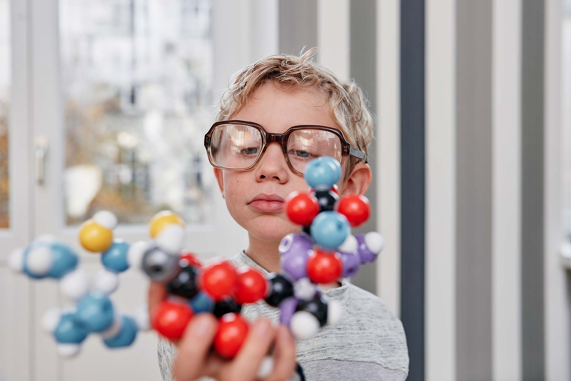A child scientist looks at the molecular model