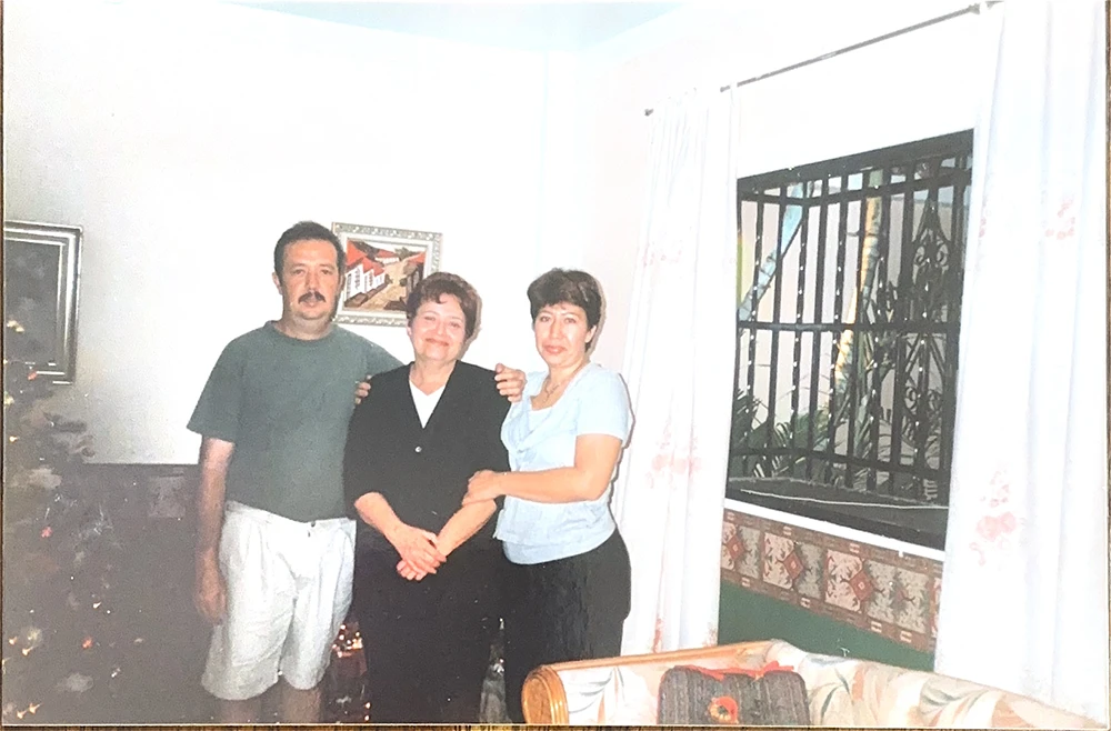 Two women and a man posing for photo.