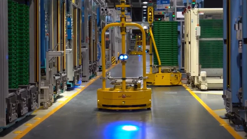A manufacturing plant with automated equipment running along the aisles.