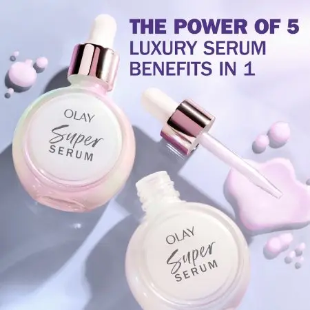 Two pinkish iridescent bottles of OLAY Super Serum lay flat against a lavender background. One bottle is open and shows the pink, lavender serum. Text identifies “The Power of 5 Luxury Benefits in 1.”