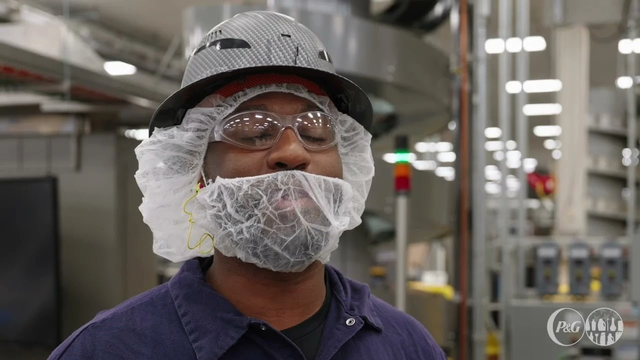 Employee wearing protective gear standing in factory production area