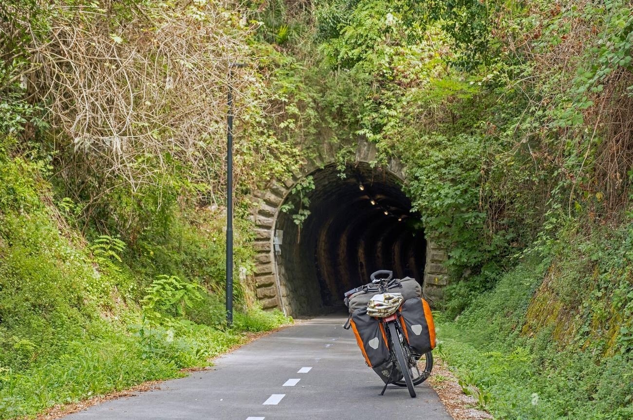 bici-da-trekking-di-fronte-al-vecchio-tunnel-ferroviario-sulla-pista-ciclabile