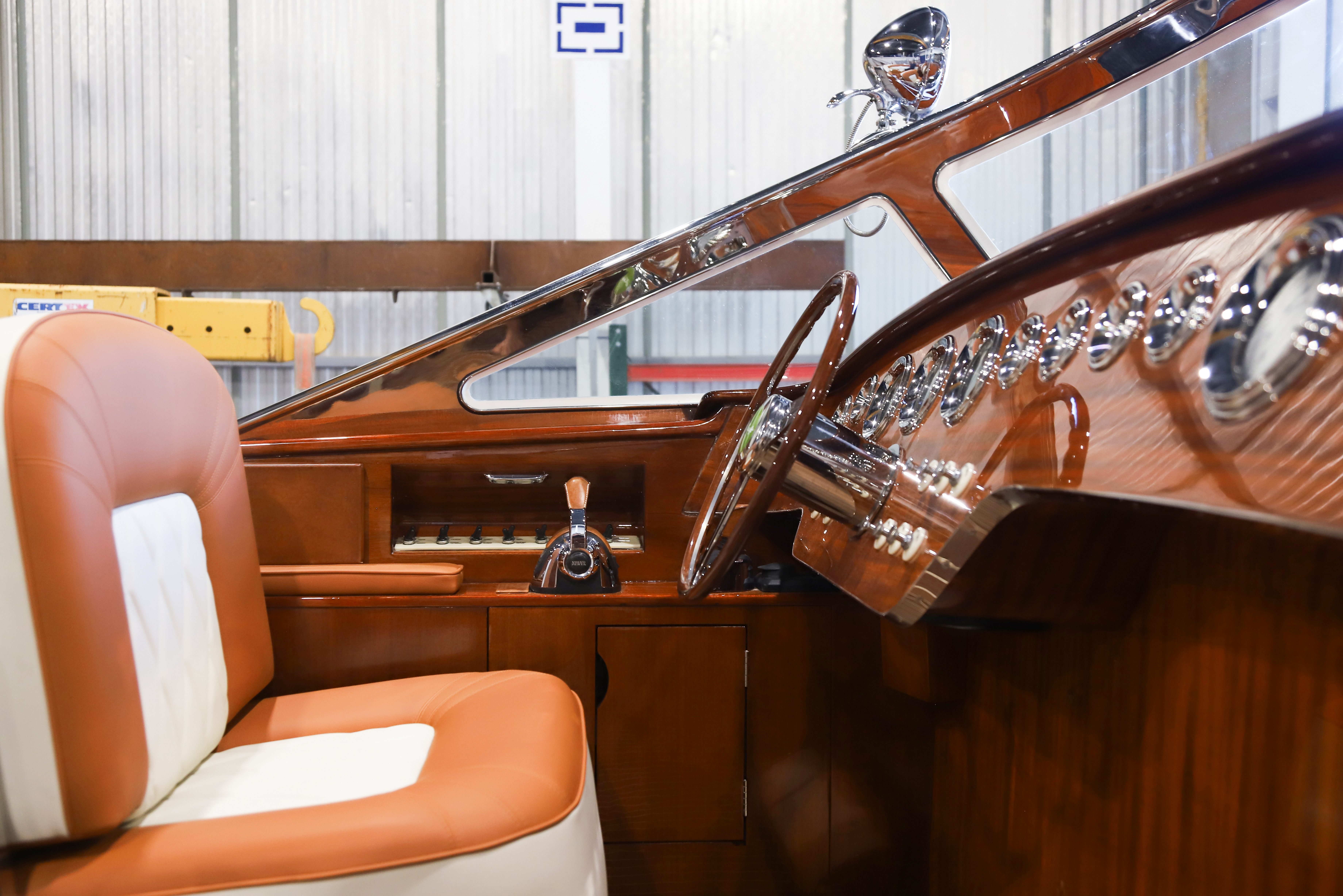 Marine leather, mahogany and the hand-cast, rose-polished steel windscreen meet at the helm.