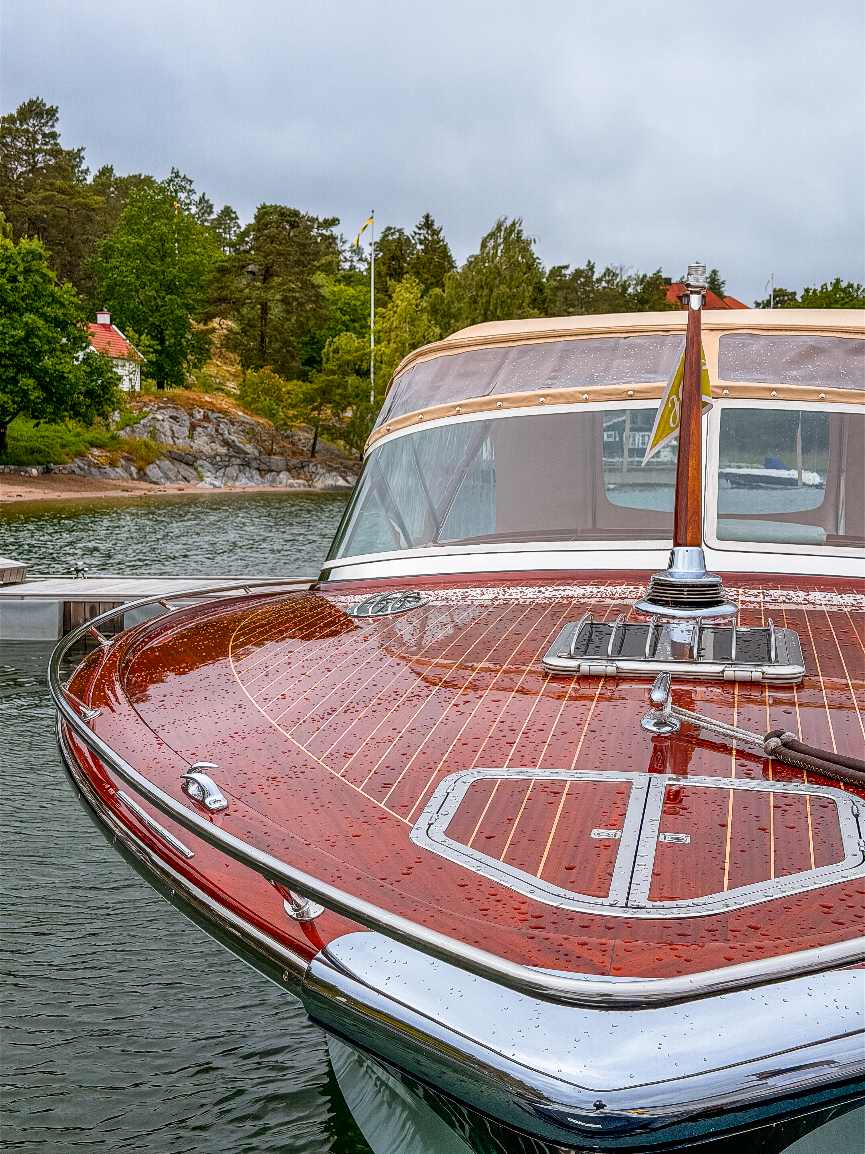 Mahogany foredeck, freshly varnished and beaded with rain.