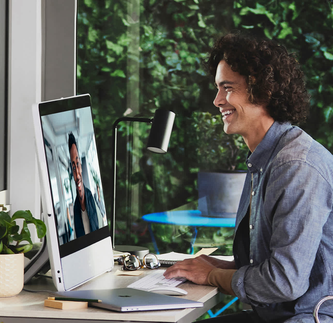 Desk device at home with a man smiling and having a pleasant conversation over webex