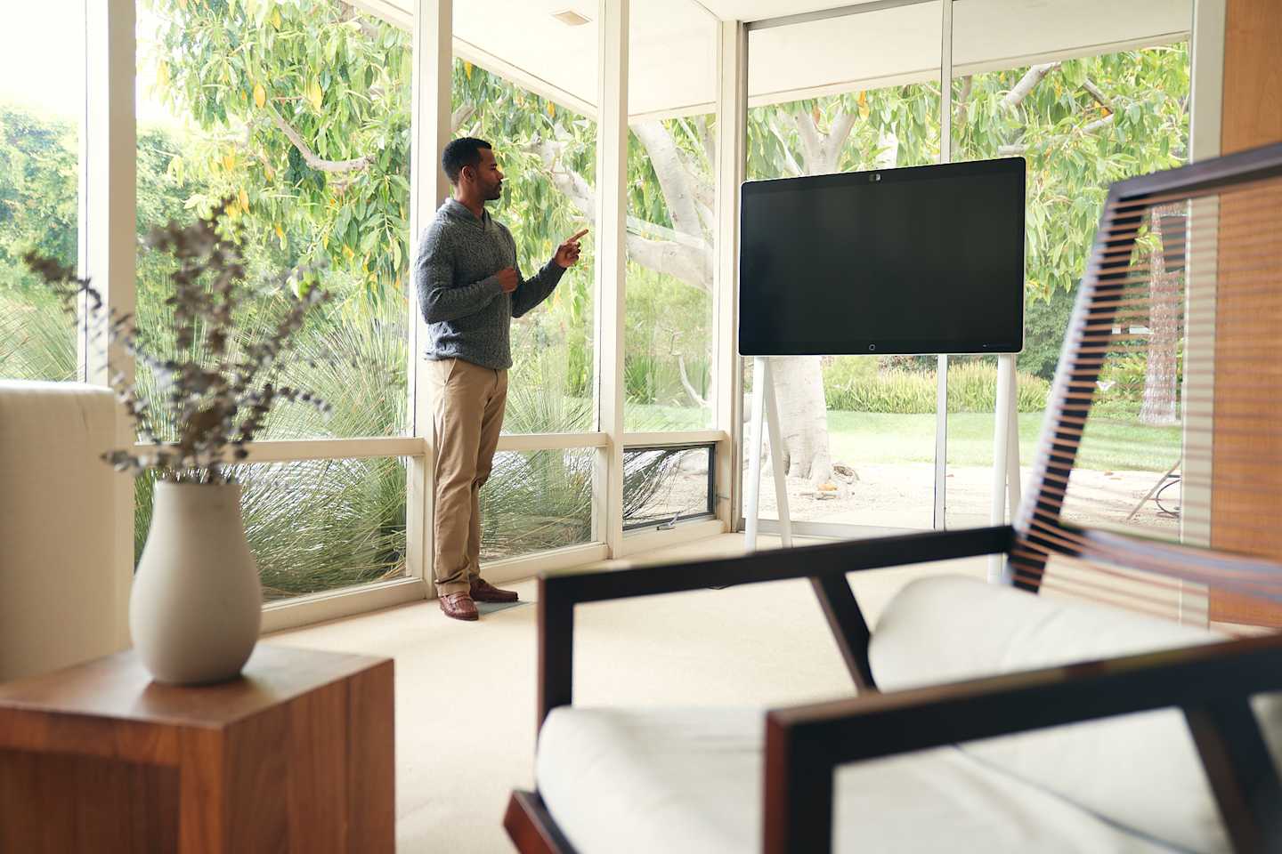 A man pointing at a board in a living room.