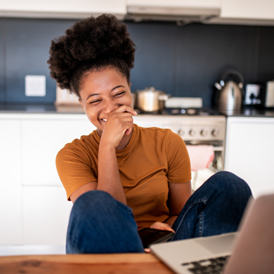 A woman is enjoying video streaming content on a laptop