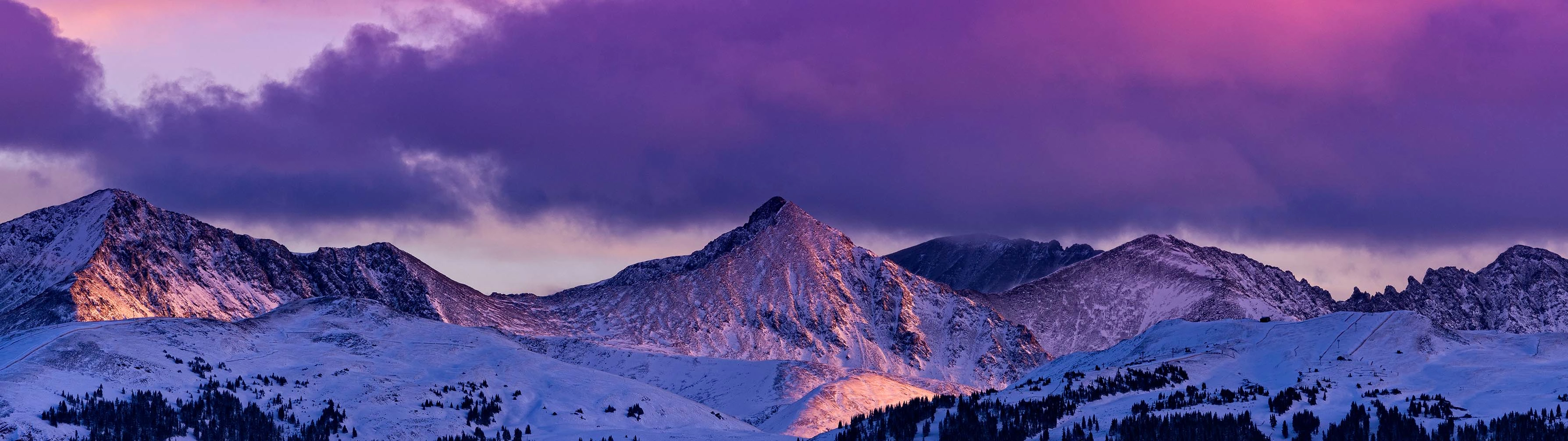 Purple skies stand behind the imposing white peak of Copper Mountain.