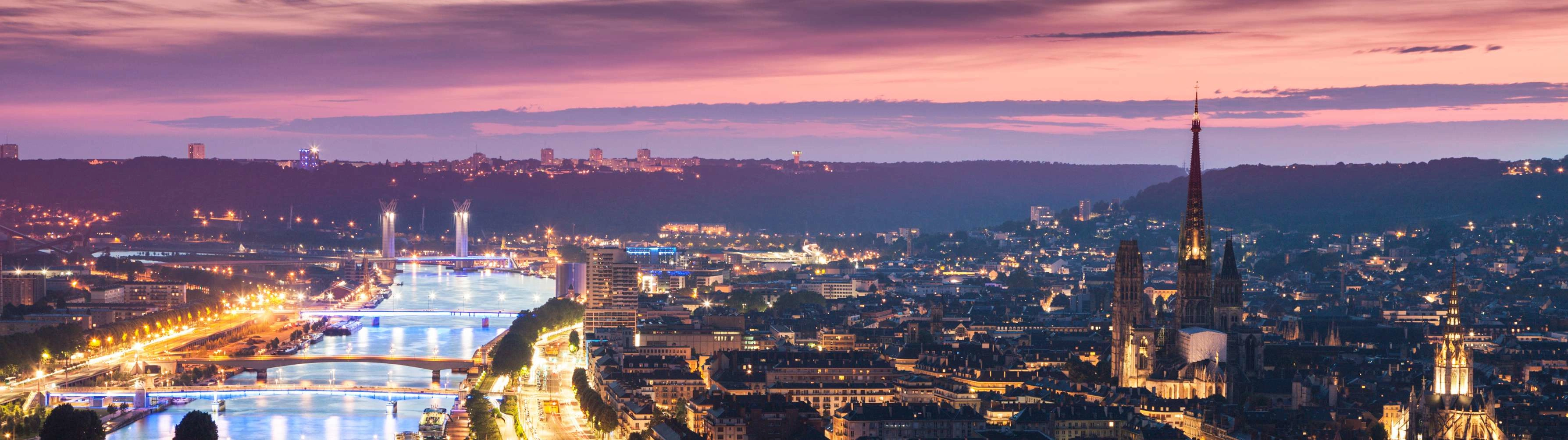 An aerial shot of the town of Roune, lit up at night.