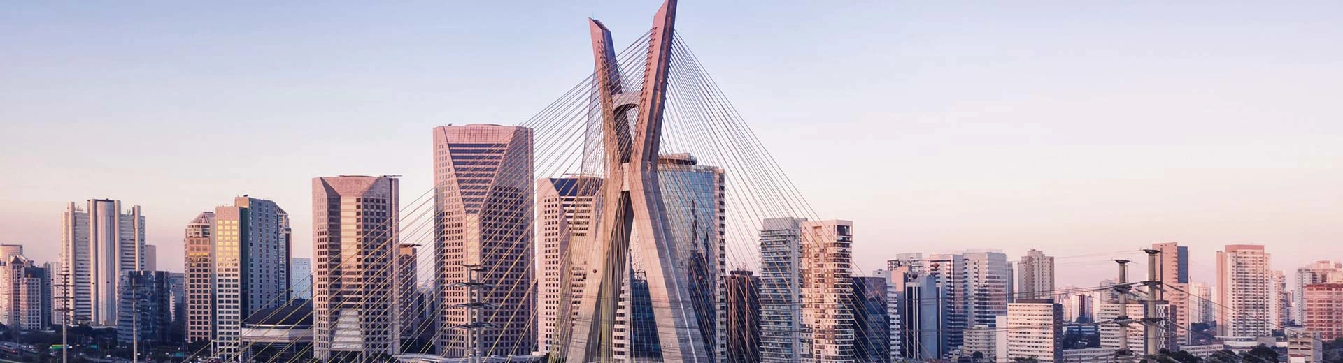 La extensa metrópolis de Sao Paulo a la tenue luz del anochecer, hay múltiples rascacielos en el fondo.